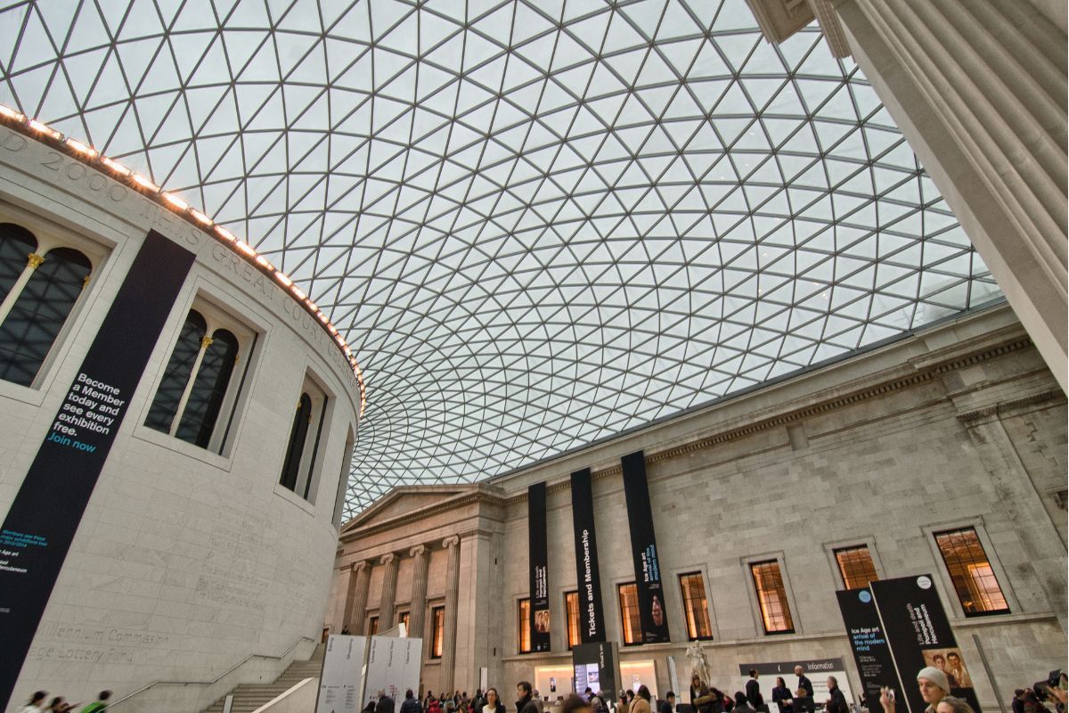 Lobby de entrada do Museu Britânico com grande teto de vidro e com muitas pessoas caminhando