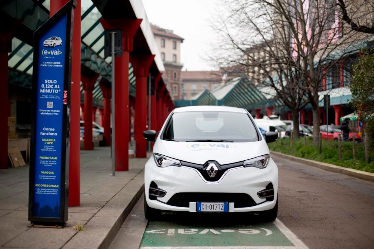 Carro elétrico da empresa E-Vai, de carros compartilhados, estacionado em vaga em frente a estação de trem