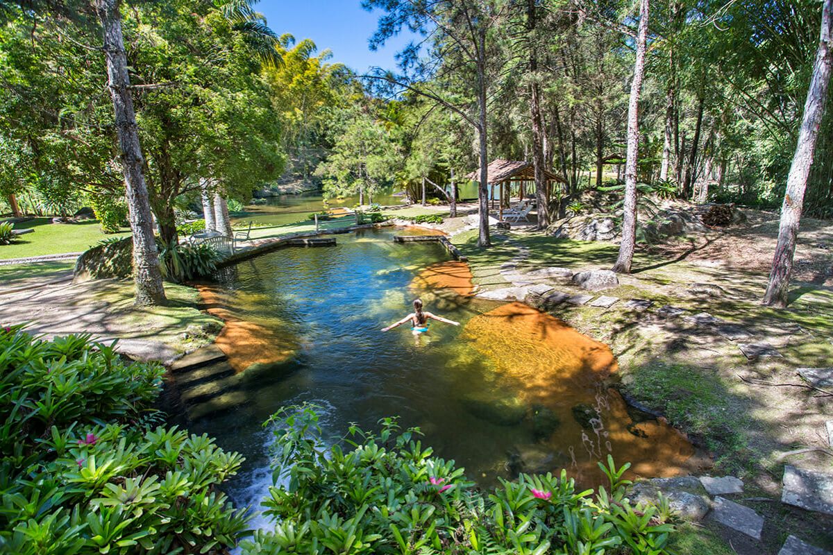 Mulher em piscina natural de pousada na Serra Fluminense