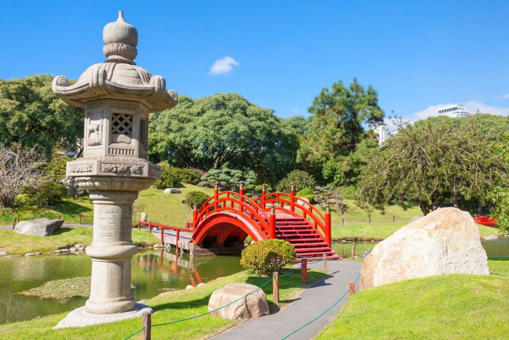 Ponte vermelha, lago e escultura típica japonesa no Jardim Japonês de Buenos Aires