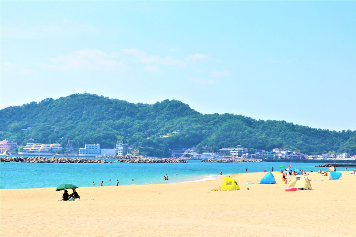 Pessoas na praia de Kataonami em dia ensolarado