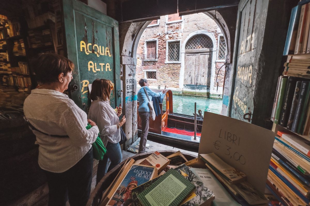 Turistas em fila para foto na Livraria Acqua Alta, Veneza