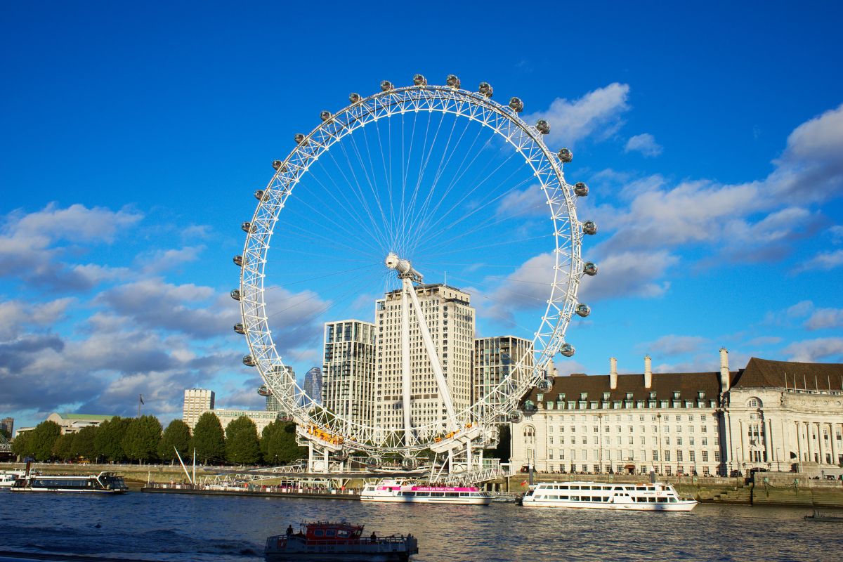 Roda gigante London Eye em frente ao rio Tâmisa em dia de sol