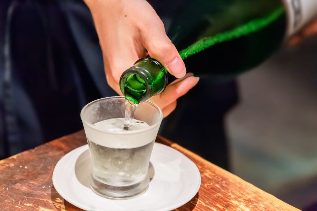 Garçonete servindo uma dose de sakê em um bar