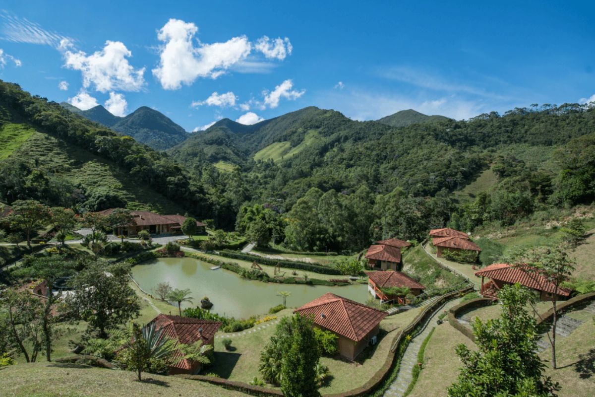 Panorama de chalés e lago em hospedagem de Lumiar
