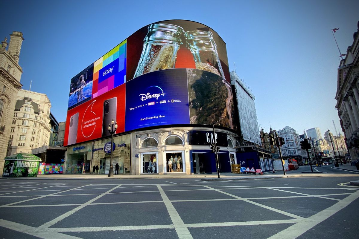Esquina da Piccadilly Circus com enormes painéis publicitários luminosos e lojas de grife