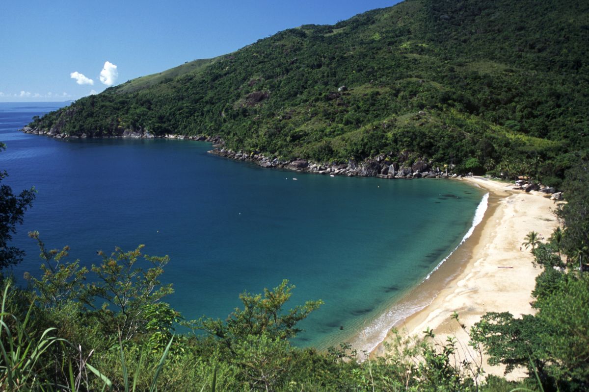 Praia do Jabaquara, em Ilhabela, vista de cima com areias claras e mar azul escuro