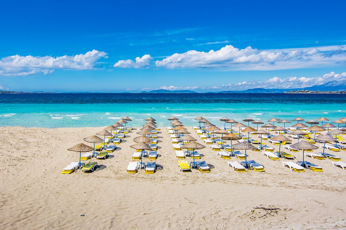 Praia de Ilica, a Turquia, com mar azul e guarda-sóis na areia
