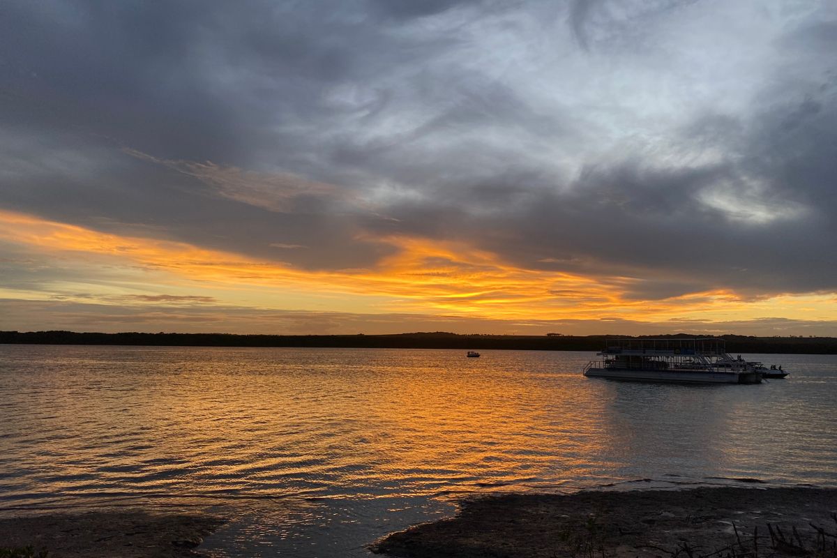 Barco em pôr do sol na Praia do Jacaré, na Paraíba