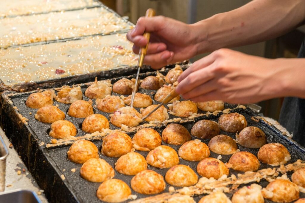 Chef preparando o takoyaki em uma barraca de rua no Japão