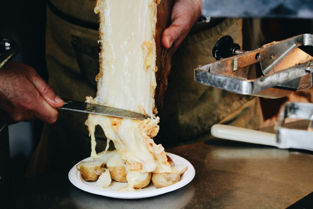 Prato de raclette com queijo derretido em cima de batatas