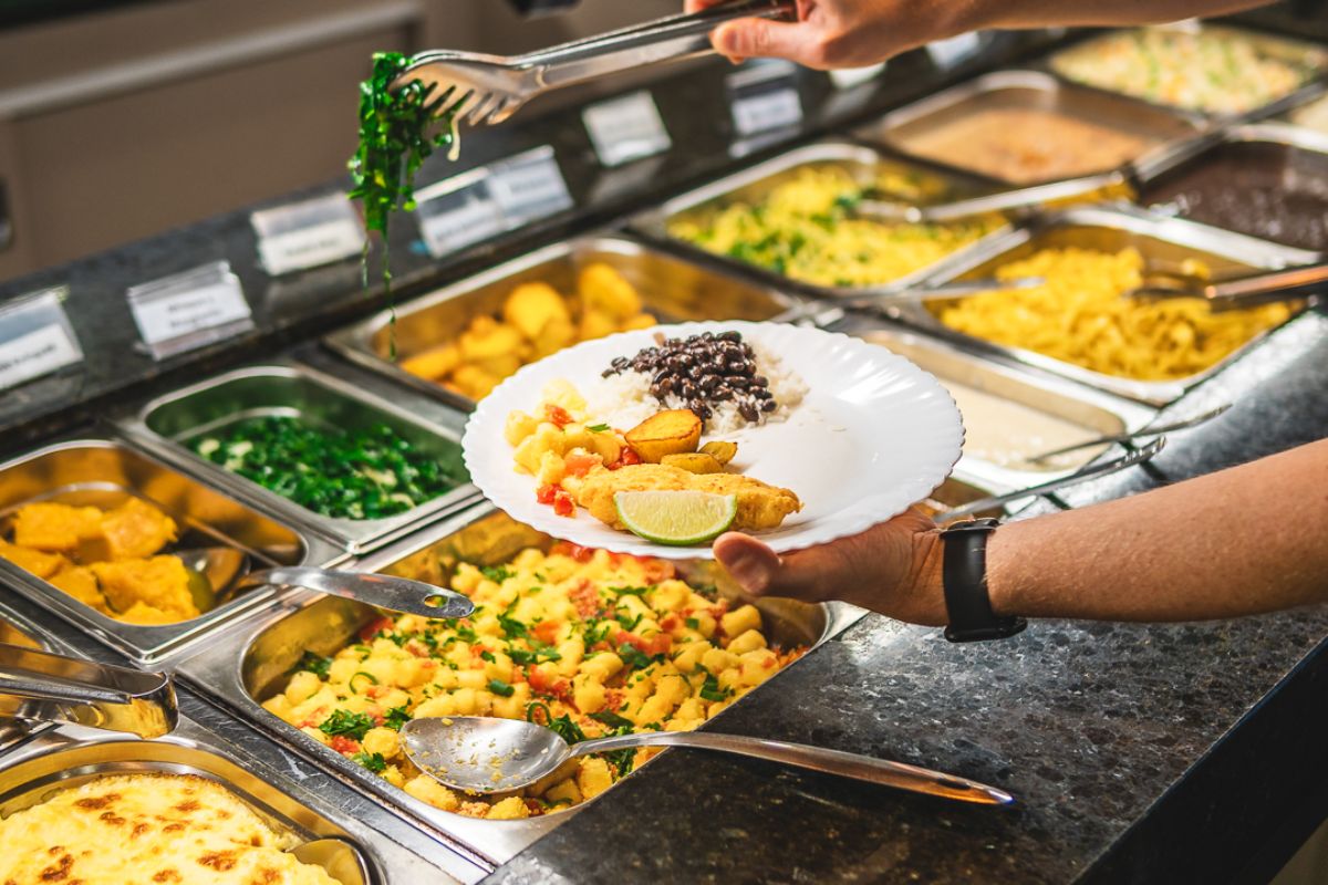 Pessoa se servindo em buffer de restaurante de Gramado