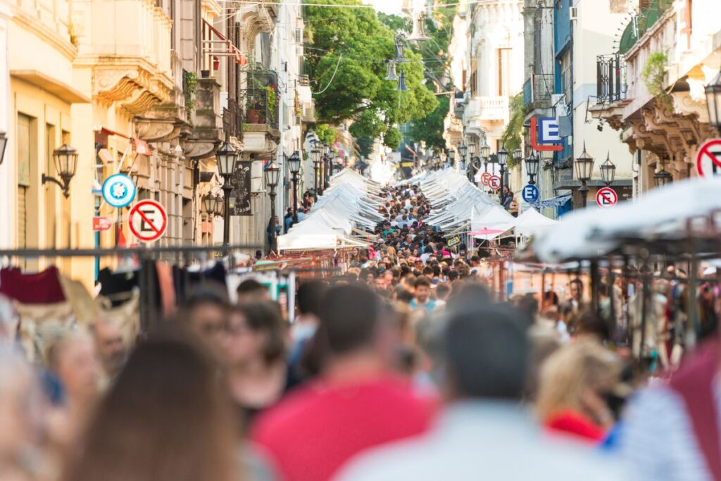 Feira de San Telmo com rua lotada de gente e barraquinhas de toldo branco