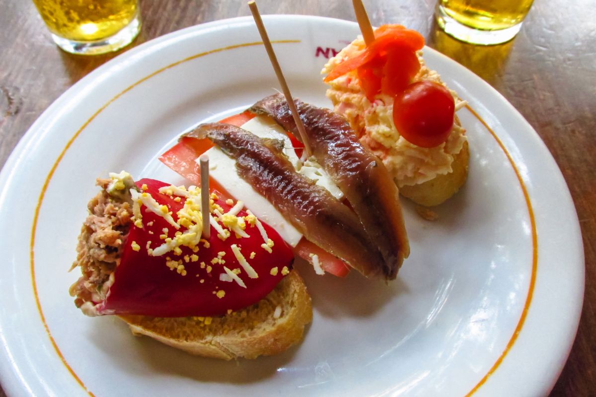 Tradicionais tapas espanholas da região da Andaluzia, com três pequenas torradas recheadas de produtos da gastronomia regional.