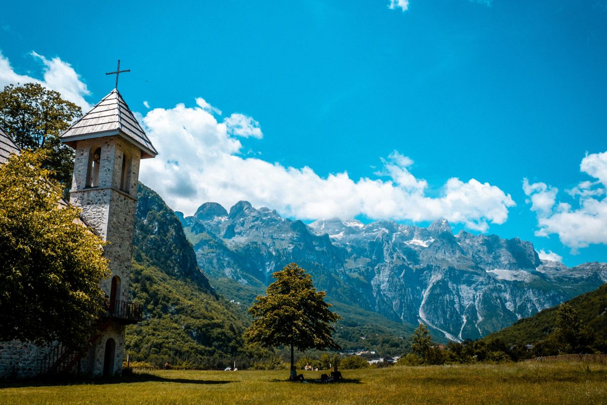 Igreja de Theth com Alpes Albaneses ao fundo