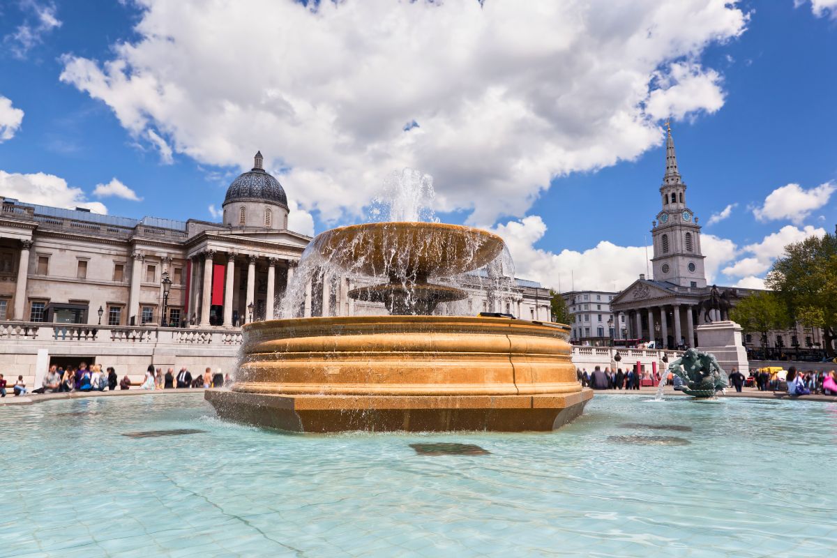 Praça Trafalgal Square com chafariz ao meio e, ao fundo, a fachada do museu National Gallery