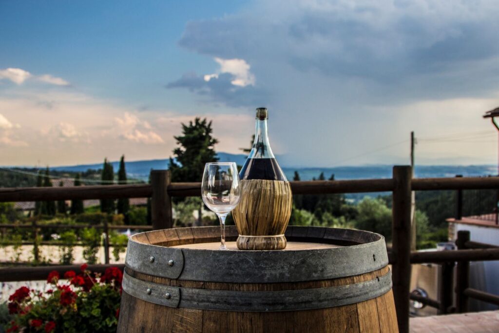 Garrafa de vinho chianti em paisagem tipicamente toscana